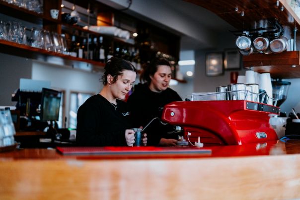 2 people making coffee at a cafe