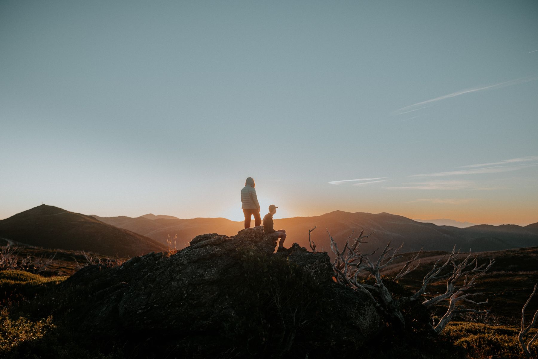 two hikers at Fall Creek alpine resort watching summer sunset